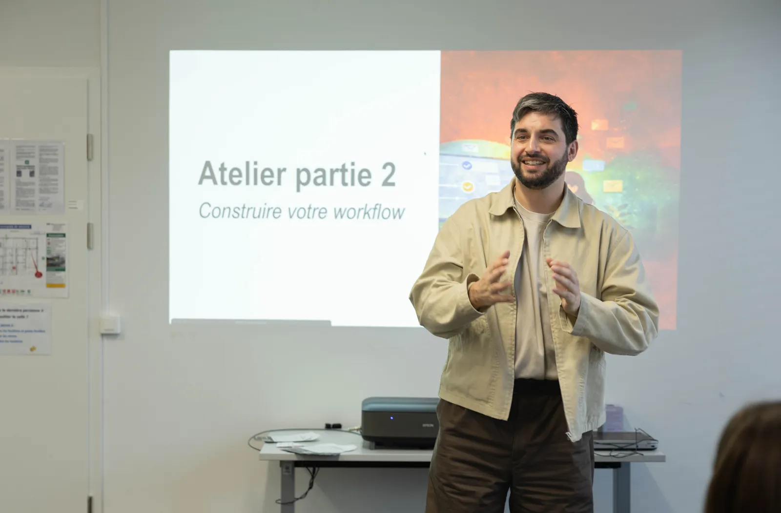 Vue large de la salle pendant le bootcamp n8n 2026, participants debout et assis en discussion
